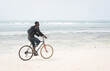 © Jasmin Merdan - African young man riding bike on tropical beach