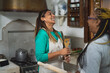 © Alessandro Biascioli - Happy multiracial women having fun in the kitchen preparing a homemade recipe in vintage house