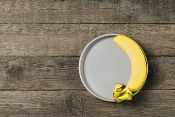 Wall Mural - Light plate with a banana on a decorative background