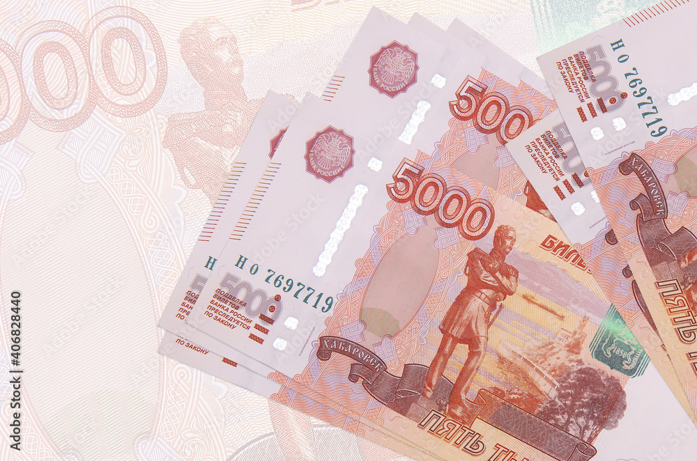 5000 russian rubles bills lies in stack on background of big semi-transparent banknote. Abstract presentation of national currency