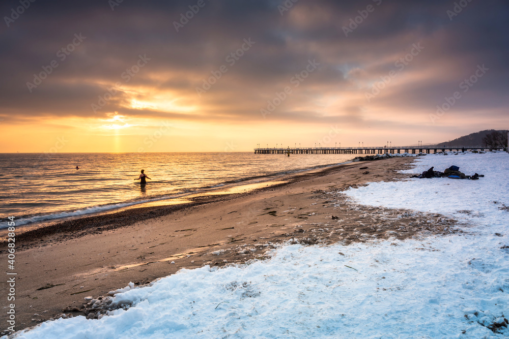 Amazing snowy beach in Gdynia Orlowo at sunrise, Baltic Sea. Poland - obrazy, fototapety, plakaty 
