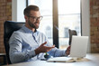 © Friends Stock - Mirthful employee looking at the laptop screen and smiling