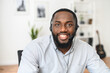 © Vadim Pastuh - Smiling young African-American office worker wearing a headset and looking at the camera, a positive man with the beard working in the customer service department, making and receiving calls