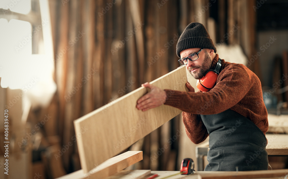 brutal male carpenter working in  workshop - obrazy, fototapety, plakaty 