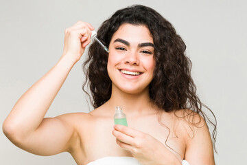 Wall Mural - Portrait of a woman putting on moisturizing serum