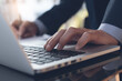 © tippapatt - Closeup of businessman hand typing on laptop computer, surfing the internet, working at office