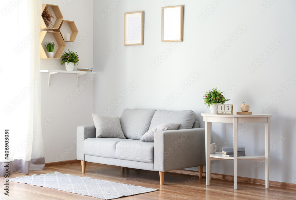 Stylish interior of living room with sofa - obrazy, fototapety, plakaty 