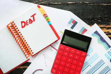 Wall Mural - Notebook with word DEBT, documents and calculator on table