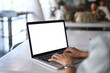 © Prathankarnpap - Close up view young woman hands typing on keyboard of laptop computer. White empty screen for advertise text.