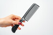 © fotofabrika - Female hand holding hair comb against white background