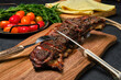 Grilled lamb breast and flap on wooden cutting board