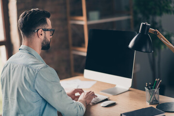 Photo portrait back view of man working on pc with blank space on screen at table in modern industrial office indoors