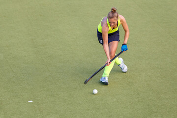 Wall Mural - Young field hockey female player in attack