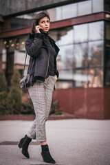 Wall Mural - Beautiful young business woman talking on phone in city. Female using mobile phone on the street