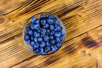 Sticker - Blueberry in glass bowl on a wooden table. Top view