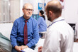 © DC Studio - Senior man discussing with healthcare practitioner during healthcare appointment. Elderly patient having a converstation with medical stuff in private clinic during consultation.