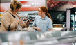 Grocery store worker helping female customer