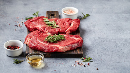 Wall Mural - Two Fresh Raw meat Prime Black Angus Beef Steaks, Rib Eye, Denver, on wooden cutting board.