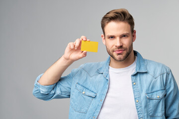 Wall Mural - Handsome happy young man showing blank bank cor discount card