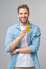 Wall Mural - Handsome happy young man showing blank bank cor discount card