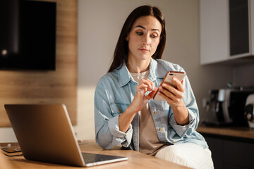 Wall Mural - Beautiful woman using mobile phone and laptop computer