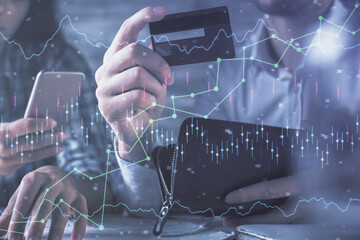 Fototapete - Double exposure of man and woman on-line shopping holding a credit card and forex graph hologram drawing. Stock market E-commerce pay on-line concept.