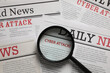 © New Africa - Newspaper with headline CYBER ATTACK under magnifying glass, top view