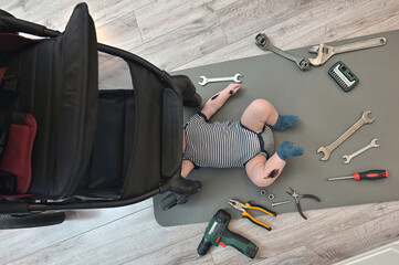 Mechanic Little Boy Repairing of A Baby Stroller