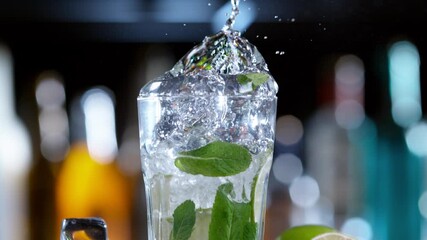 Wall Mural - Super slow motion of falling ice cube into mojito drink, camera movement. Filmed on high speed cinema camera, 1000 fps.