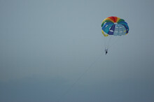 Recreational Activity Known As Parascending Or Parasailing Enjoyed By Tourists Visiting The Island; Adrenaline Seekers Strapped By A Parachute Enjoying Being Airborne, Tenerife, Canary Islands, Spain