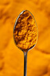Turmeric powder on a spoon, top view