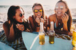 © Criene Images - Happy group of female friends drinking beer at the beach and having fun on vacation