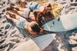 © Criene Images - Young adult women friends laying on the beach together with surfboards