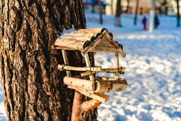 Togliatti, Russia - 18 Jan 2021: Wooden feeder in the form of a house in winter, Russian inscriptions