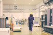 © Mangostar - African American female industrial employee in hardhat and overall walking on plant floor. Back view. Work in factory or labor concept