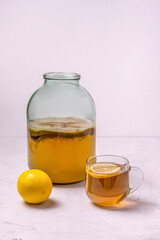 Wall Mural - kombucha in a glass jar and lemon on a concrete background