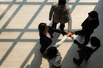 Wall Mural - view from above of multiethnic business team touching hands together as a sign of unity in internation corporate office. diversity in business concept