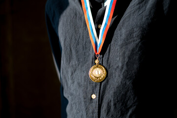 male sportsman with a golden medal on a chest, champion leader