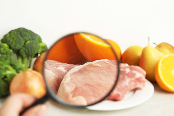 Wall Mural - woman with magnifying glass exploring raw meat and fruits, closeup. poison detection