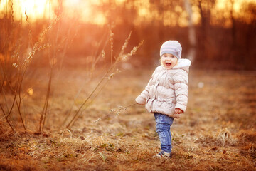 Wall Mural - early spring, girl walking on the street, buds swollen, sunset evening in spring