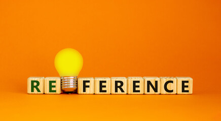 Reference symbol. Wooden cubes with the word 'reference'. Yellow light bulb. Beautiful orange background. Business and reference concept. Copy space.