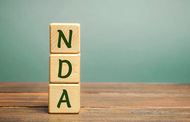 Wooden blocks with the word NDA - Non disclosure agreement. A legal contract entered into by two parties with limited access to third parties. Business concept