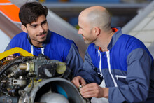 Two Engineers Talking While Working In A Hangar
