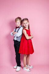 Wall Mural - Valentine's Day concept..Cute smiling boy and girl standing on a pink background .