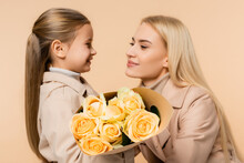 Yellow Roses In Hands Of Child Near Mother On 8 March And Blurred Background Isolated On Beige