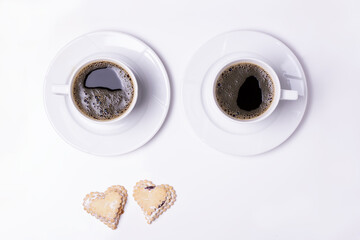 Heart-shaped cookies on a white plate with coffee. Background for Valentine's Day.