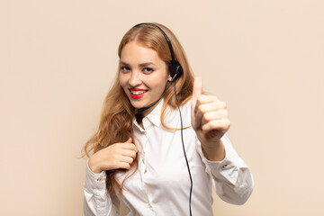 blonde woman feeling proud, carefree, confident and happy, smiling positively with thumbs up