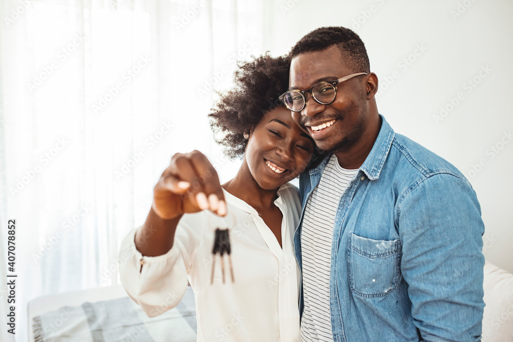 Happy young family couple holding key to new home on moving day concept ...