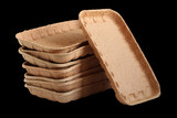 Fototapeta Tulipany - Biodegradable food trays made from pressed cardboard isolated on black background. Closeup