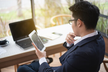 business man working with tablet and laptop in the coffee shop